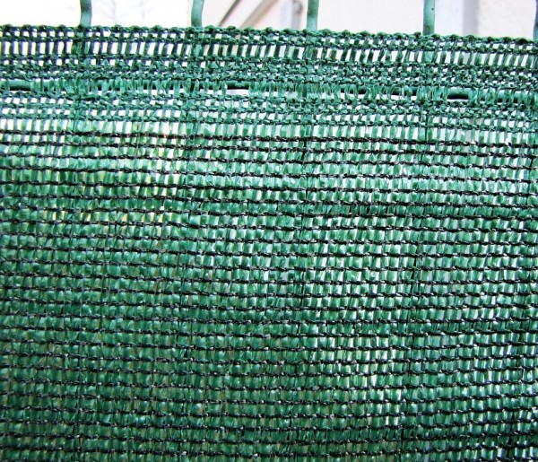 Detail řidší zelené stínící tkaniny
